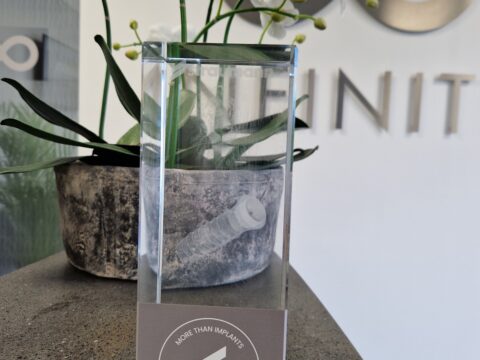 A glass display object showing a dental implant on the side of the infinity clinic.