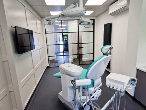 The inside of the clinic showing the patients dental chair and lights