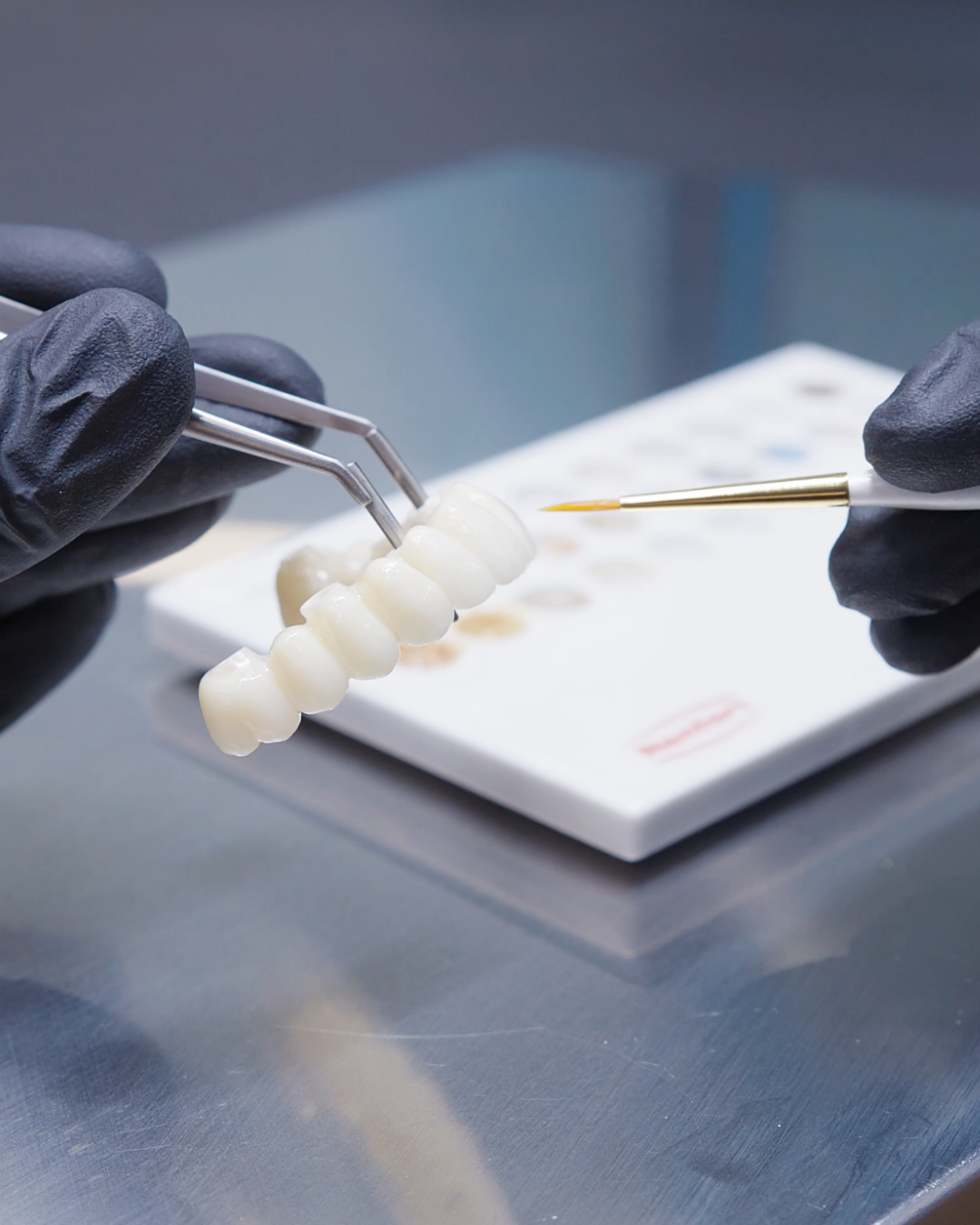 Full Arch Dental Implants Leeds and Harrogate Infinity Dental in-house laboratory technicians hand painting dental restorations in Leeds