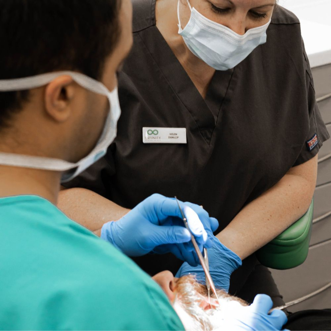 Full Arch Dental Implants Leeds and Harrogate Dentist discussing root canal treatment costs with a patient at Infinity Dental Clinic in Leeds