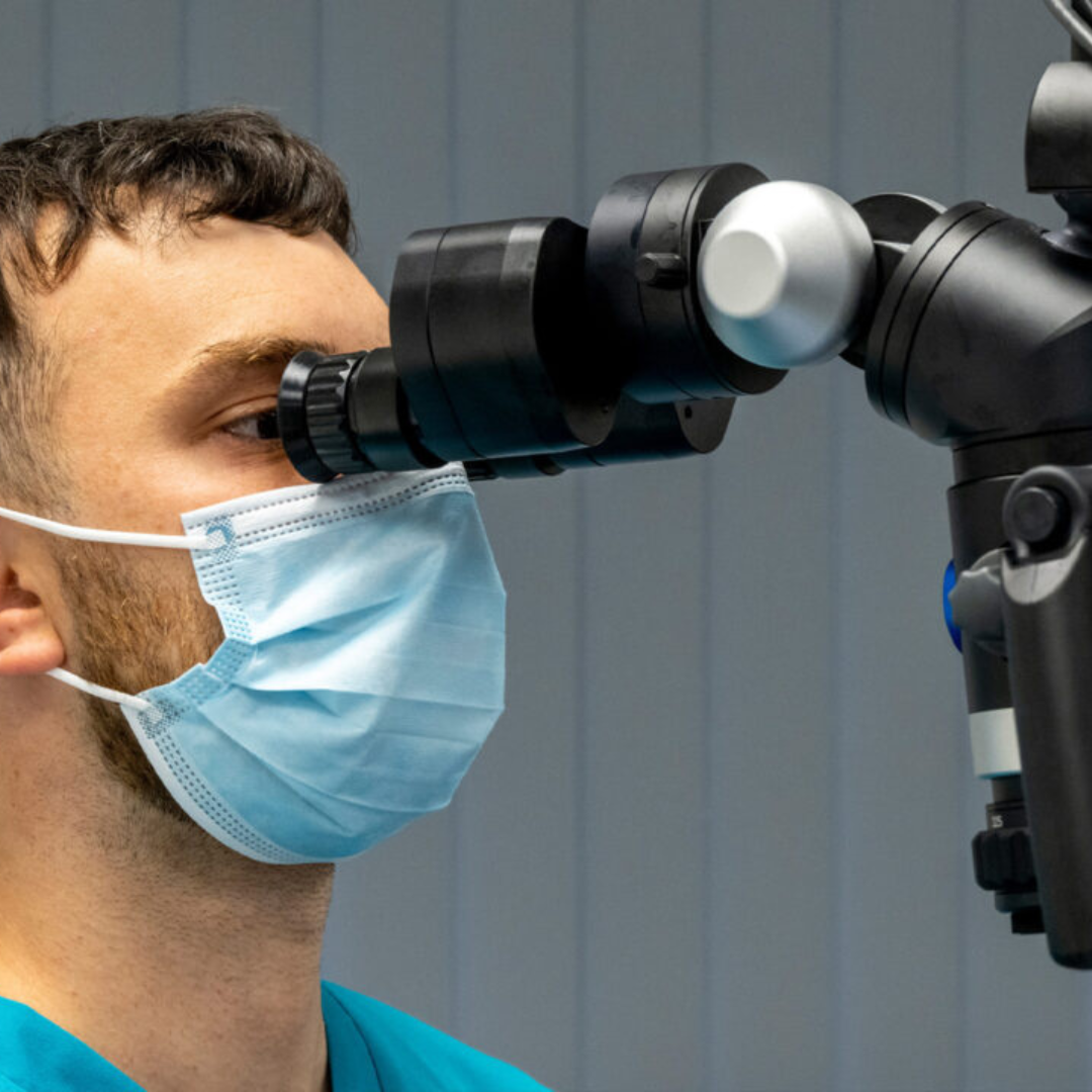 Full Arch Dental Implants Leeds and Harrogate Dentist using an endodontic microscope during root canal treatment at Infinity Dental Clinic in Leeds